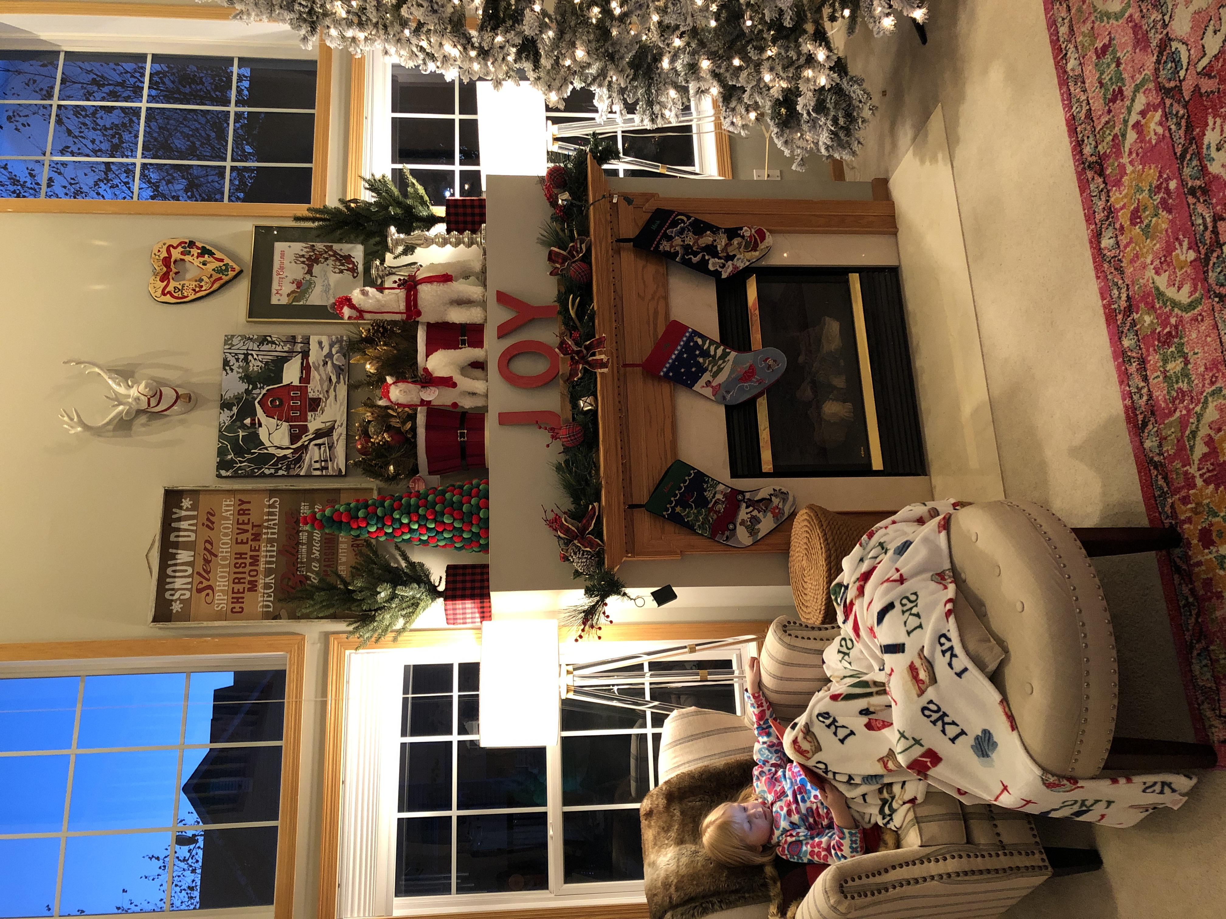 Holiday mantel styling with layered Christmas decor and flocked tree